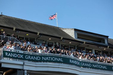 Yarışçılar, 5 Nisan 2025 tarihinde İngiltere 'nin Liverpool kentindeki Aintree Yarış Pisti' nde düzenlenen Randox Grand National 2025 Ulusal Günü 'ne bakıyorlar.