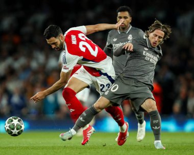Arsenal 'den Mikel Merino, Real Madrid' den Luka Modri ile UEFA Şampiyonlar Ligi çeyrek final maçında Emirates Stadyumu, Londra, Birleşik Krallık 'ta 8 Nisan 2025 tarihinde oynanan Arsenal - Real Madrid karşılaşmasında top için mücadele ediyor.