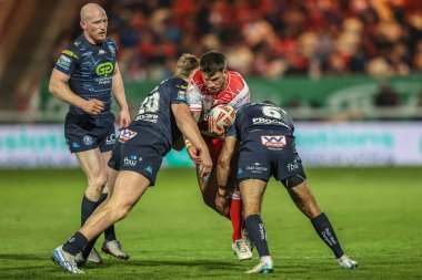 Oliver Gildart, Wigan Warriors 'dan Harvie Hill ve Wigan Warriors' tan Bevan French tarafından 7. Betfred Süper Lig karşılaşmasında yenildi. Hull KR, Wigan Warriors 'a karşı Sewell Group Craven Park, Kingston üzerine Hull, Birleşik Krallık, 11 Nisan 2025