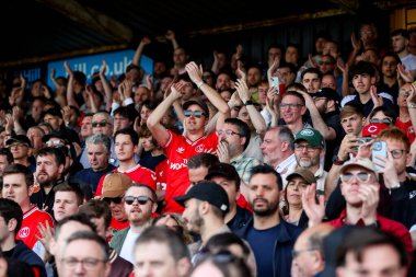 Charlton Athletic taraftarları, 12 Nisan 2025 'te Cledara Abbey Stadyumu' nda oynanan Cambridge United - Charlton Athletic maçının ardından takımların galibiyetini kutluyor.