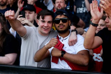 Charlton Athletic taraftarları, 12 Nisan 2025 'te Cledara Abbey Stadyumu' nda oynanan Cambridge United - Charlton Athletic maçının ardından takımların galibiyetini kutluyor.