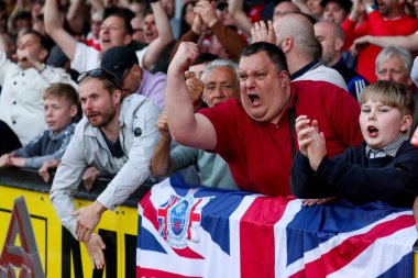 Charlton Athletic taraftarları, 12 Nisan 2025 'te Cledara Abbey Stadyumu' nda oynanan Cambridge United - Charlton Athletic maçının ardından takımların galibiyetini kutluyor.