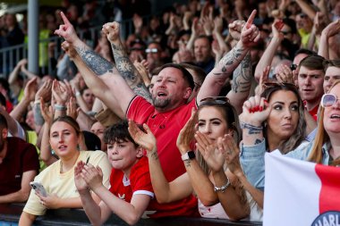 Charlton Athletic taraftarları, 12 Nisan 2025 'te Cledara Abbey Stadyumu' nda oynanan Cambridge United - Charlton Athletic maçının ardından takımların galibiyetini kutluyor.