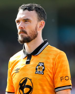 Cambridge United takımından Scott Malone, 12 Nisan 2025 'te Cledara Abbey Stadyumu' nda oynanan Cambridge United - Charlton Athletic maçından önce sıralanıyor.