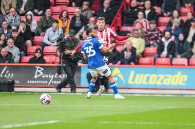 Sheffield United takımından Harrison Burrows, 18 Nisan 2025 'te Sheffield Lane, İngiltere' de oynanan Sky Bet Şampiyonası maçında Cardiff City 'den Andy Rinomhota' nın baskısıyla topu geçiyor.