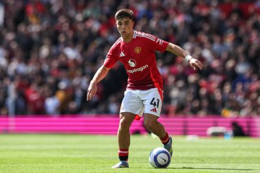 Manchester United takımından Harry Amass, Manchester United ve Wolverhampton Wanderers maçında 20 Nisan 2025 'te Old Trafford, Manchester' da top ile ilerliyor.