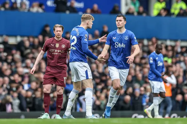 Everton 'dan Michael Keane, Everton Premier League maçında Everton, Manchester City' ye karşı Goodison Park, Liverpool, Birleşik Krallık 'ta 19 Nisan 2025' de yedeği Jarrad Branthwaite ile el sıkışıyor.