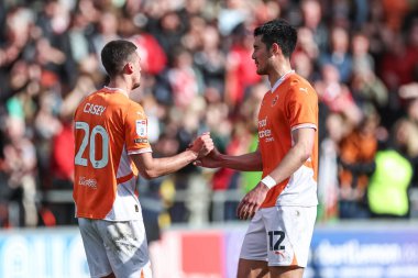 Blackpool 'dan Oliver Casey, Blackpool' dan Elkan Baggott ile 21 Nisan 2025 'te Bloomfield Road, Blackpool' da oynanan Blackpool-Wrexham maçında el sıkışıyor.