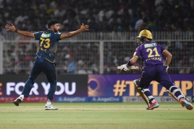 Hindistan Premier Ligi (IPL) 20. kriket karşılaşmasında Kolkata Şövalyeleri ve Gujarat Titanları arasında Cennet Bahçeleri 'nde oynanan Kolkata Şövalyeleri Rahamanullah Gurbaz' ın mağlup edilişini, soldaki Gujarat Titanları kutluyor. 