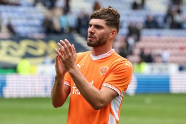 Blackpool 'dan Tom Bloxham, 26 Nisan 2025' te İngiltere 'nin Wigan kentindeki Brick Community Stadyumu' nda oynanan Wigan Atletizm - Blackpool maçının son düdüğü çaldıktan sonra taraftarları alkışlıyor.