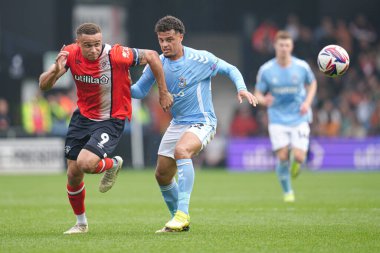 Luton Town 'dan Carlton Morris ve Coventry City' den Joel Latibeaudiere 26 Nisan 2025 'te Luton Town, Luton, İngiltere' de Coventry City 'ye karşı oynanan Gökyüzü İddia Şampiyonası maçında top mücadelesi veriyorlar.