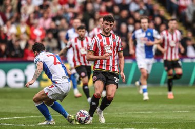 Sheffield United takımından Thomas Cannon, 3 Mayıs 2025 'te Sheffield Lane, Sheffield, Birleşik Krallık' ta oynanan Sky Bet Şampiyonası karşılaşmasında Blackburn Rovers takımından Lewis Travis ile karşı karşıya geldi.