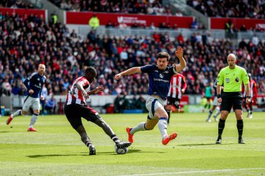 Brentford 'lu Michael Kayode, Premier League karşılaşmasında Manchester United' lı Harry Maguire 'ın 4 Mayıs 2025' te Gtech Community Stadyumu 'nda Manchester United' a karşı oynadığı maçta baskı altında.