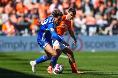 Bristol Rovers takımından Isaac Hutchinson ve Blackpool takımından Rob Apter, 3 Mayıs 2025 'te Bloomfield Road, Blackpool' da oynanan Blackpool-Bristol Rover maçında top için mücadele ettiler.