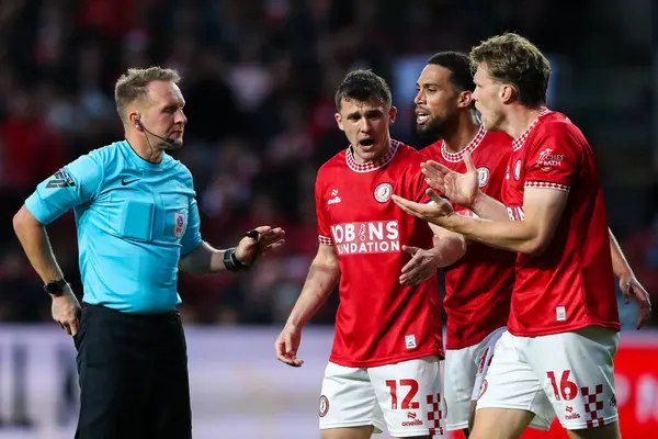 Bristol City 'deki oyuncular Bristol City' li Rob Dickie 'ye 8 Mayıs 202 tarihinde Bristol, İngiltere' deki Ashton Gate 'de Bristol City ile Sheffield United arasındaki yarı final maçında hakem Oliver Langford tarafından gösterilen kırmızı kartı protesto ettiler.