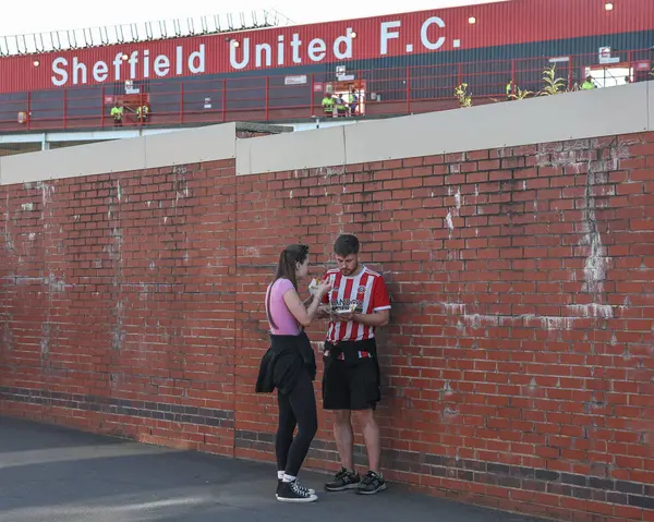 Bramall Lane 'in dışında balık ve patates yiyen iki taraftar, 12 Mayıs 2025' te İngiltere 'nin Sheffield Lane şehrinde oynanan yarı final maçında Sheffield United ile Bristol City arasında oynanacak.