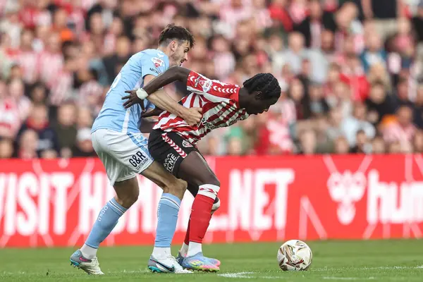 Sunderland 'dan Eliezer Mayenda, 13 Mayıs 2025' te İngiltere 'nin Sunderland kentinde oynanan Gökyüzü İddia Şampiyonası yarı final karşılaşmasında Coventry City' den Liam Kitching 'e faul yaptı.