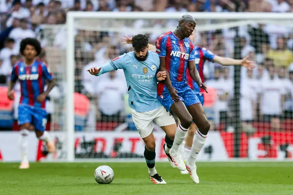 Manchester City 'den Josko Gvardiol, 17 Mayıs 202' de İngiltere 'nin Wembley Stadyumu' nda oynanan FA Cup final maçı sırasında Kristal Saray 'da Kristal Saray' dan Jean-Philippe Mateta ile top mücadelesi veriyor.