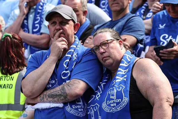 İki Everton taraftarı, 18 Mayıs 2025 'te Goodison Park, Liverpool, İngiltere' de oynanan Premier League maçından sonra mirası kutlayarak ve Goodison Park 'tan ayrıldıktan sonra üzüntüyle kucaklaşıyor.