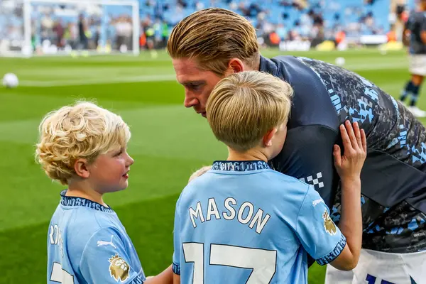 Manchester City 'den Kevin De Bruyne, 20 Mayıs 202' de Etihad Stadyumu 'nda oynanan Premier League maçından önce çocuklarıyla etkileşim halindedir.