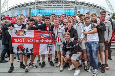 Sunderland taraftarlarından oluşan bir grup, 24 Mayıs 2025 'te İngiltere' nin Wembley Stadyumu 'nda Sheffield United ile Sunderland arasındaki final maçı öncesinde bayrak kaldırıyor.