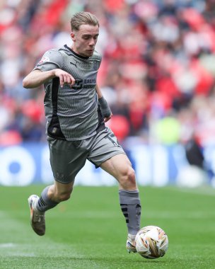 Leyton Orient takımından Jack Currie, 25 Mayıs 2025 'te Wembley Stadyumu' nda oynanan Charlton Atletizm ve Leyton Orient maçında topu ayaklarının dibine aldı.