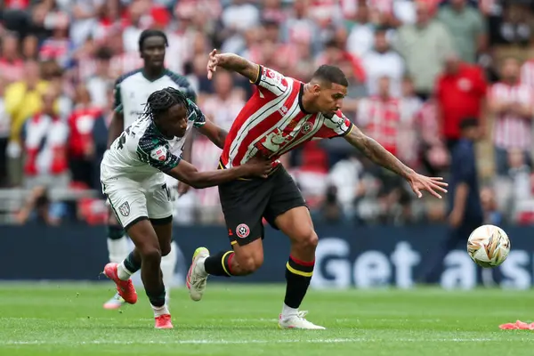 Sunderland 'dan Romaine Mundle, Sheffield United' dan Vinicius Souza 'yı 24 Mayıs 2025' te Wembley Stadyumu 'nda Sheffield United ile Sunderland arasındaki final maçında tutuyor.