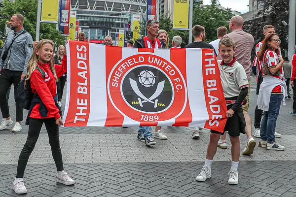 Sheffield United 'ın iki genç taraftarı, 24 Mayıs 2025' te Wembley Stadyumu 'nda Sheffield United ile Sunderland arasındaki final maçı öncesinde bayrak kaldırdı.
