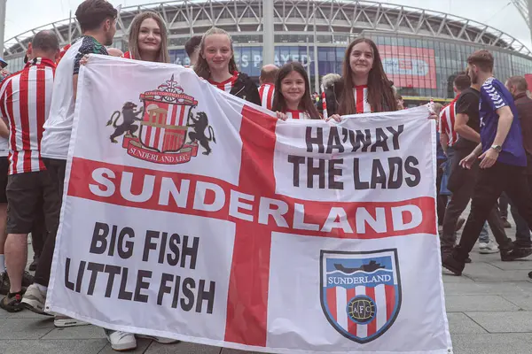 Sunderland taraftarlarından oluşan bir grup, 24 Mayıs 2025 'te İngiltere' nin Wembley Stadyumu 'nda Sheffield United ile Sunderland arasındaki final maçı öncesinde bayrak kaldırıyor.