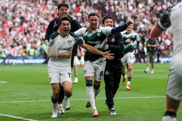 Sunderland 'dan Luke O' Nien ve Sunderland 'dan Alan Browne, 24 Mayıs 2025' te İngiltere 'nin Wembley Stadyumu' nda oynanan Gökyüzü İddia Şampiyonası Playoff Finali 'nin ardından Premier Lig' e geri dönmelerini kutluyorlar.