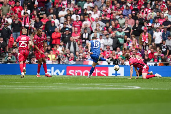 AFC Wimbledon takımından Marcus Browne, 26 Mayıs 2025 'te Wembley Stadyumu' nda oynanan ve Wimbledon 'a karşı oynanan, Sky Bet 2 Playoff final maçında uzak mesafeden şutunu atıyor.