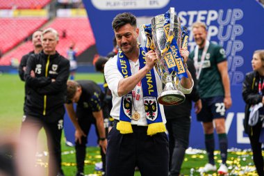 AFC Wimbledon teknik direktörü Johnnie Jackson, 26 Mayıs 2025 'te Wembley Stadyumu' nda oynanan Wimbledon-Walsall maçında Sky Bet 2 playoff final maçı sonrasında kupa ile kutluyor.