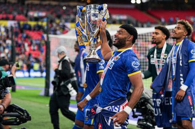 AFC Wimbledon takımından Ryan Johnson, 26 Mayıs 2025 'te Wembley Stadyumu' nda oynanan Wimbledon-Walsall maçından sonra taraftarlarıyla birlikte reklamı kutluyor.
