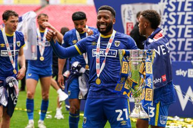 AFC Wimbledon takımından Myles Hippolyte, 26 Mayıs 2025 'te Wembley Stadyumu' nda oynanan Wimbledon-Walsall maçından sonra kupayla kutluyor.