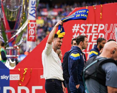 AFC Wimbledon teknik direktörü Johnnie Jackson 26 Mayıs 2025 'te Wembley Stadyumu' nda Wimbledon 'a karşı AFC Wimbledon finalinden sonra eşarp sallıyor.