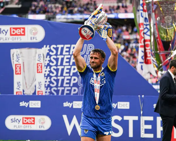 AFC Wimbledon takımından Joe Lewis, 26 Mayıs 2025 'te Wembley Stadyumu' nda oynanan Wimbledon-Walsall maçından sonra kupayı kaldırdı.