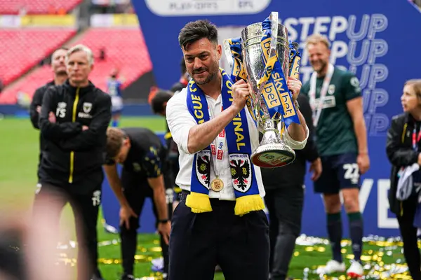 AFC Wimbledon teknik direktörü Johnnie Jackson, 26 Mayıs 2025 'te Wembley Stadyumu' nda oynanan Wimbledon-Walsall maçında Sky Bet 2 playoff final maçı sonrasında kupa ile kutluyor.