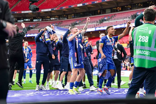 Wimbledon oyuncuları 26 Mayıs 2025 'te Wembley Stadyumu' nda oynanan AFC Wimbledon-Walsall maçından sonra taraftarlarıyla terfiyi kutladı.