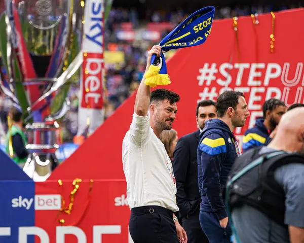 AFC Wimbledon teknik direktörü Johnnie Jackson 26 Mayıs 2025 'te Wembley Stadyumu' nda Wimbledon 'a karşı AFC Wimbledon finalinden sonra eşarp sallıyor.