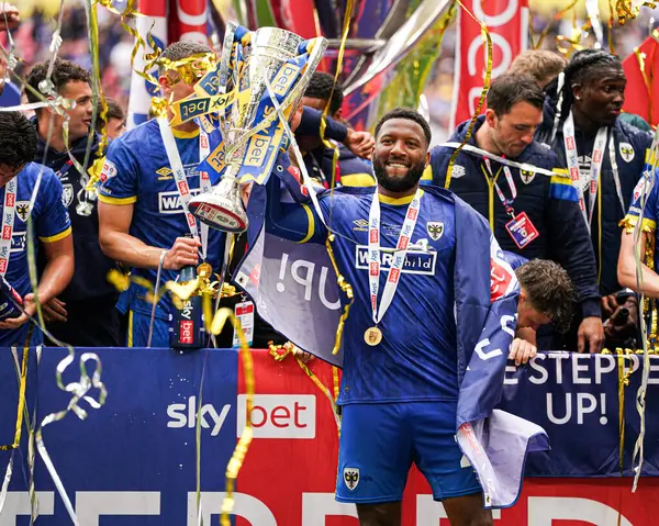 AFC Wimbledon takımından Myles Hippolyte, 26 Mayıs 2025 'te Wembley Stadyumu' nda oynanan Wimbledon-Walsall maçı sonrasında kupa ile kupayı kutluyor.