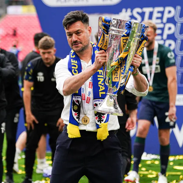 AFC Wimbledon teknik direktörü Johnnie Jackson, 26 Mayıs 2025 'te Wembley Stadyumu' nda oynanan Wimbledon-Walsall maçında Sky Bet 2 playoff final maçı sonrasında kupa ile terfisini kutluyor.