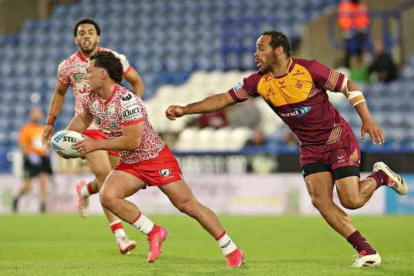 Huddersfield Giants 'dan Leroy Cudjoe, Leigh Leopards' dan Lachlan Lam 'e, 29 Mayıs 2025' te John Smith 'in Stadyumu' nda oynanan 13. Huddersfield Giants - Leigh Leopards maçında baskı yapıyor.