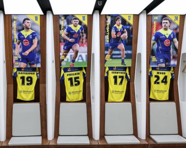 Warrington Wolves 'tan Stefan Ratchford Warrington Wolves' tan Joe Philbin Warrington Wolves 'tan Jordy Crowther Warrington Wolves' tan Max Wood soyunma odasında Betfred Challenge Cup Final Warrington Wolves vs Hull KR maçında gömleklerini giyiyor.
