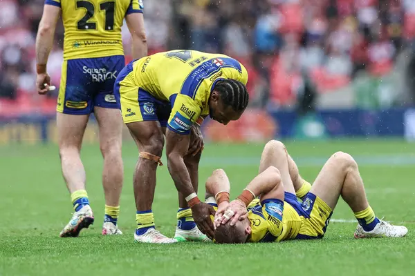 Warrington Wolves 'tan Rodrick Tai, 7 Haziran 2025' te Wembley Stadyumu 'nda oynanan Betfred Challenge Cup Final Warrington Wolves vs Hull KR maçında yaralanan Warrington Wolves' tan Matt Dufty 'i kontrol ediyor.