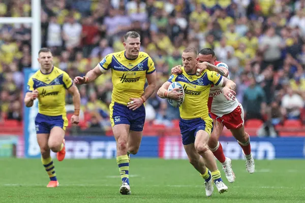 Warrington Wolves 'tan Matt Dufty, 7 Haziran 2025' te Wembley Stadyumu 'nda oynanan Betfred Challenge Cup Finali Warrington Wolves vs Hull KR maçında omuzlarında Hull KR' dan Elliot Minchella ile topu sürüyor.