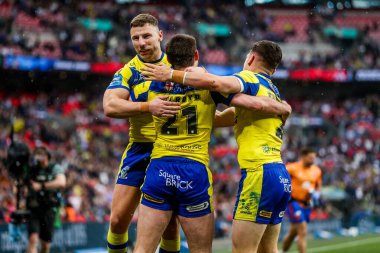 Warrington Wolves takımından Adam Holroyd, daha sonra 7 Haziran 2025 'te Londra' daki Wembley Stadyumu 'nda oynanan Betfred Challenge Cup Final Warrington Wolves vs Hull KR maçında yasaklanan takım arkadaşlarıyla denemesini kutluyor.