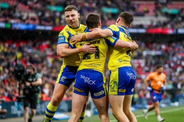 Warrington Wolves takımından Adam Holroyd, daha sonra 7 Haziran 2025 'te Londra' daki Wembley Stadyumu 'nda oynanan Betfred Challenge Cup Final Warrington Wolves vs Hull KR maçında yasaklanan takım arkadaşlarıyla denemesini kutluyor.