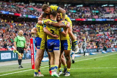 Warrington Wolves takımından Adam Holroyd, daha sonra 7 Haziran 2025 'te Londra' daki Wembley Stadyumu 'nda oynanan Betfred Challenge Cup Final Warrington Wolves vs Hull KR maçında yasaklanan takım arkadaşlarıyla denemesini kutluyor.