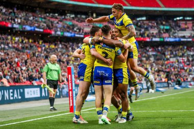 Warrington Wolves takımından Adam Holroyd, daha sonra 7 Haziran 2025 'te Londra' daki Wembley Stadyumu 'nda oynanan Betfred Challenge Cup Final Warrington Wolves vs Hull KR maçında yasaklanan takım arkadaşlarıyla denemesini kutluyor.