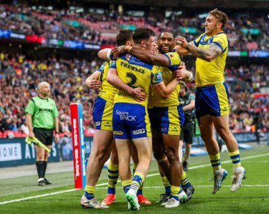 Warrington Wolves takımından Adam Holroyd, daha sonra 7 Haziran 2025 'te Londra' daki Wembley Stadyumu 'nda oynanan Betfred Challenge Cup Final Warrington Wolves vs Hull KR maçında yasaklanan takım arkadaşlarıyla denemesini kutluyor.